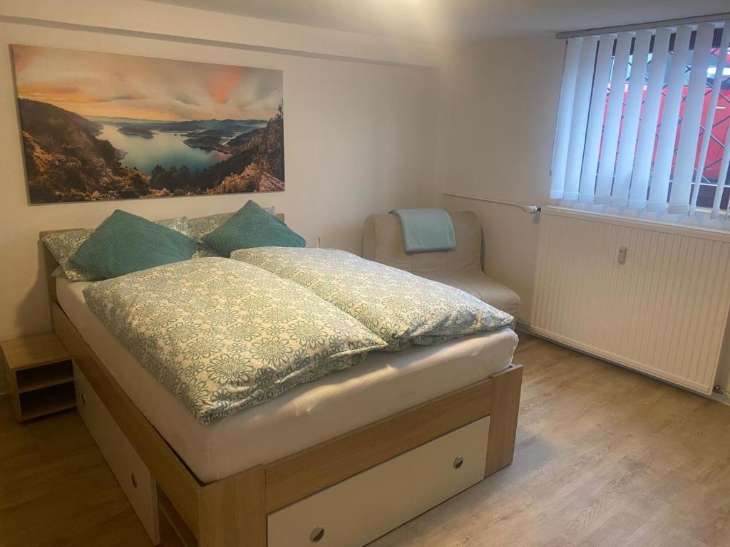 a bedroom with a bed and a chair in it at Fewo1 Am Edersee in Edertal
