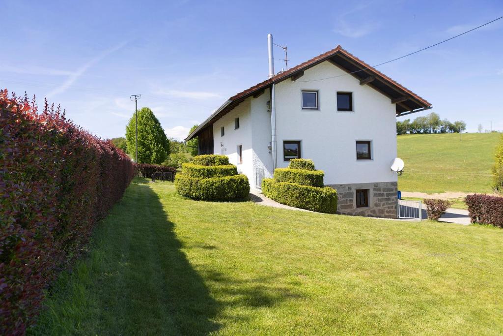 a white house with a hedge in front of it at Kreuzbergblick Bayerischer Wald in Hohenau