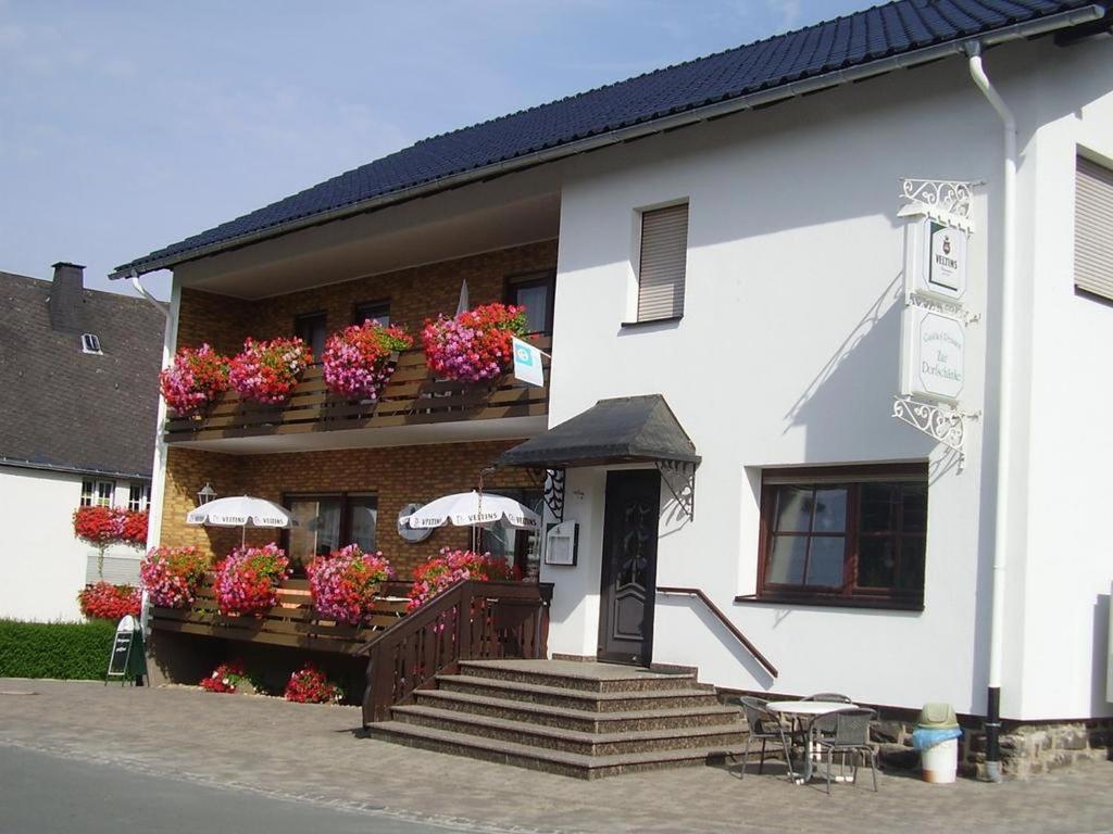 a white building with flowers on a balcony at Ferienwohnung Lisa in Medebach