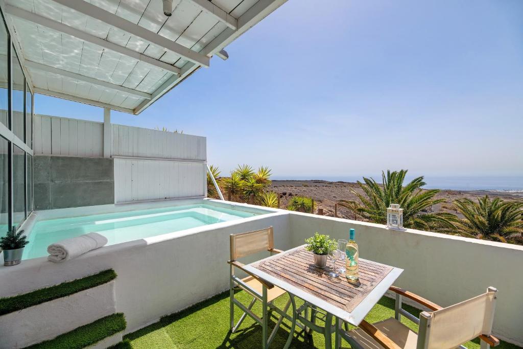 a patio with a table and a swimming pool at Loft Amanecer in Mácher