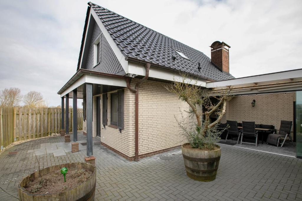 a house with a patio with a tree in a barrel at Ferienhaus Martje in Hennstedt
