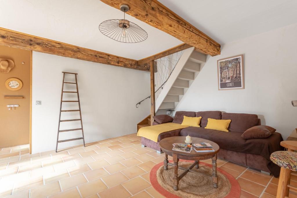 a living room with a couch and a ladder at Mas Vizern avec bain nordique in Taillet