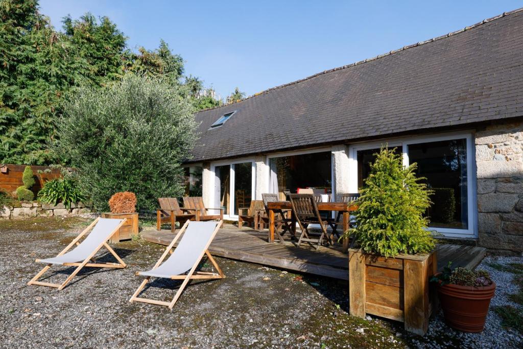 a group of chairs sitting on a wooden deck at Loft Atypique jacuzzi sauna in Cléguérec