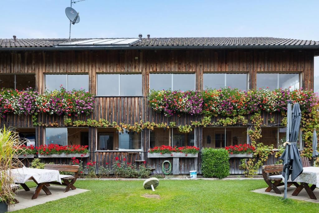 a building with flowers on the side of it at Haus Vögel in Sibratsgfäll