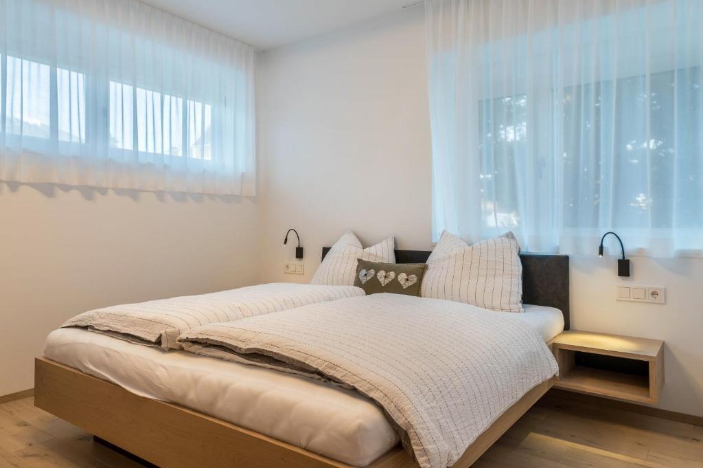 a bedroom with a bed with a large window at Mountain Meadows Apt 4 in Valdaora