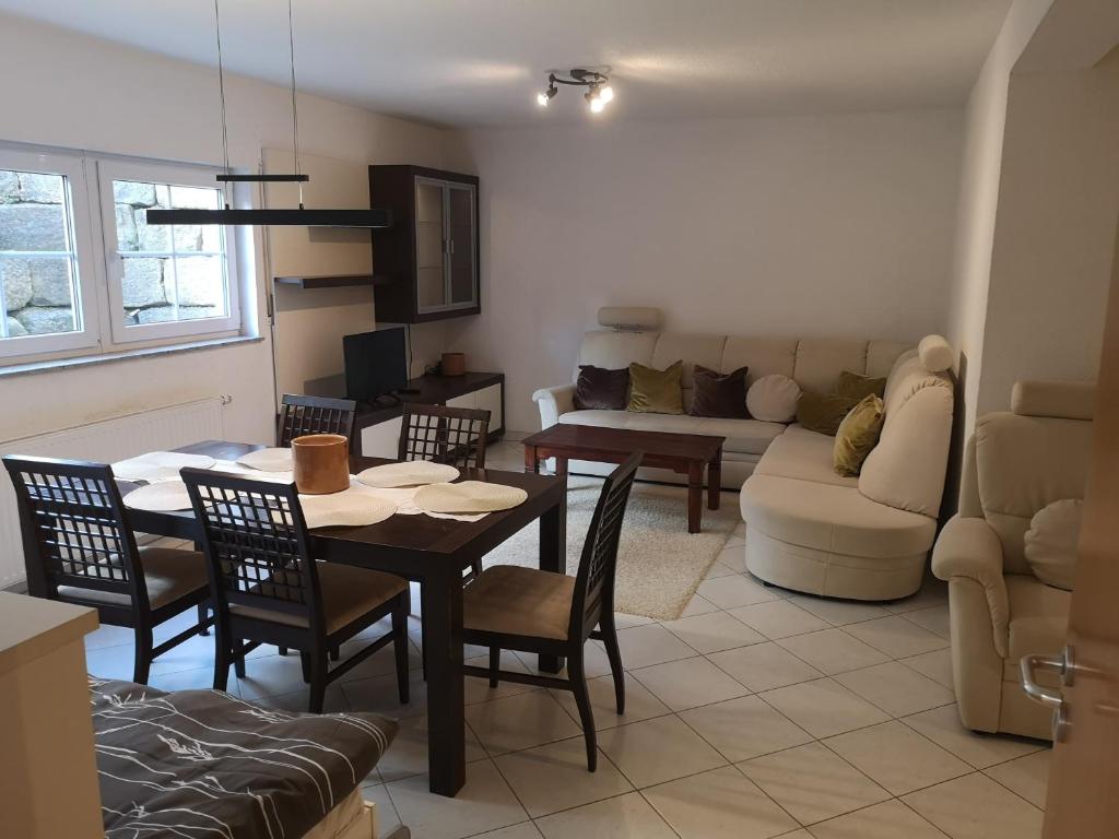 a living room with a table and chairs and a couch at Ferienwohnung Mössingen in Mössingen