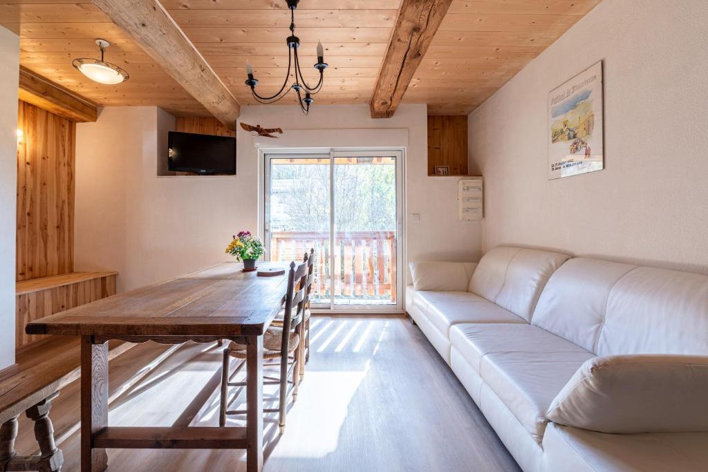 a living room with a couch and a table at Appartement Des Fontaines Albiez in Albiez-le-Jeune