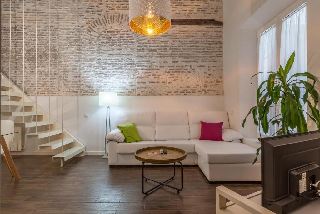 a living room with a white couch and a table at Orbyz in Seville