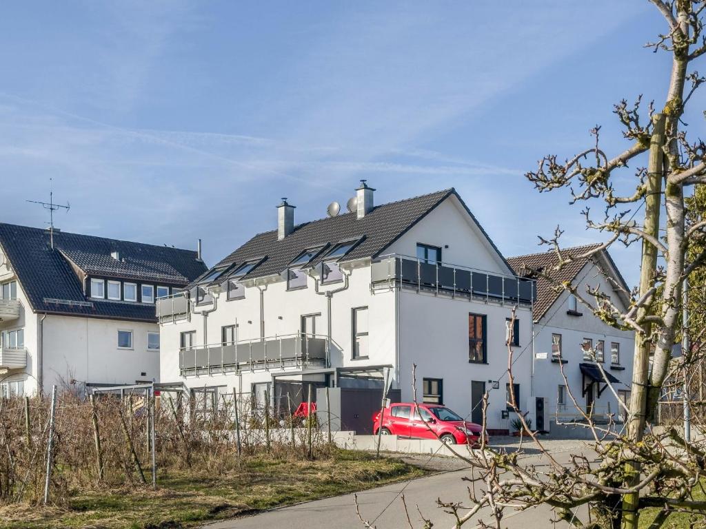 a white house with a red car parked in front of it at Haus Agatha in Wasserburg