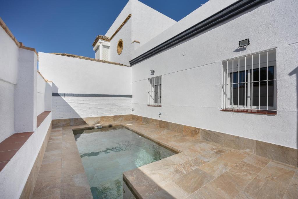 a swimming pool in the courtyard of a white building at Casa Camposoto in San Fernando