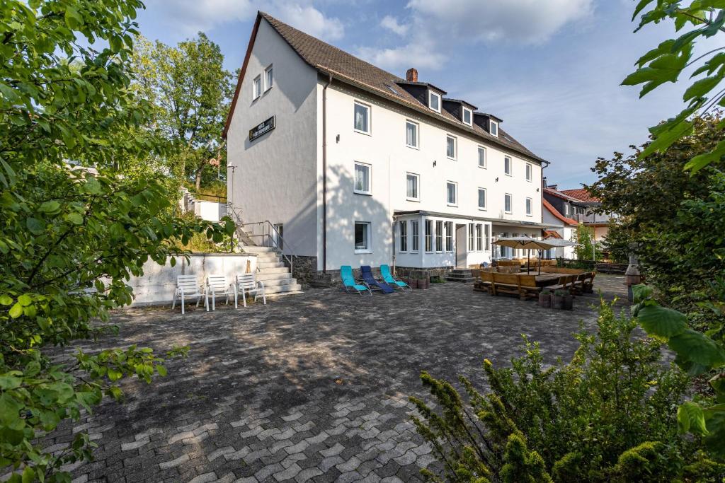a large white building with chairs and tables in front of it at Haus Fürstenberg Komplett in Fürstenberg