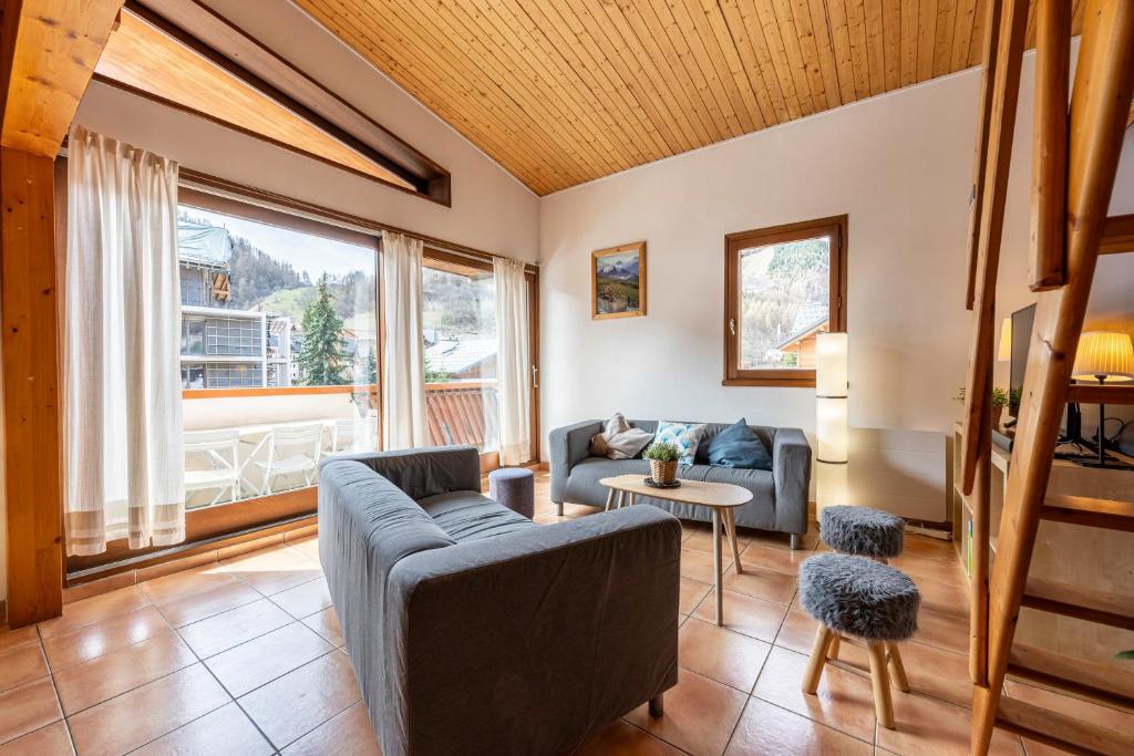 a living room with a couch and a table at La maison d’Anthelmette in Valloire