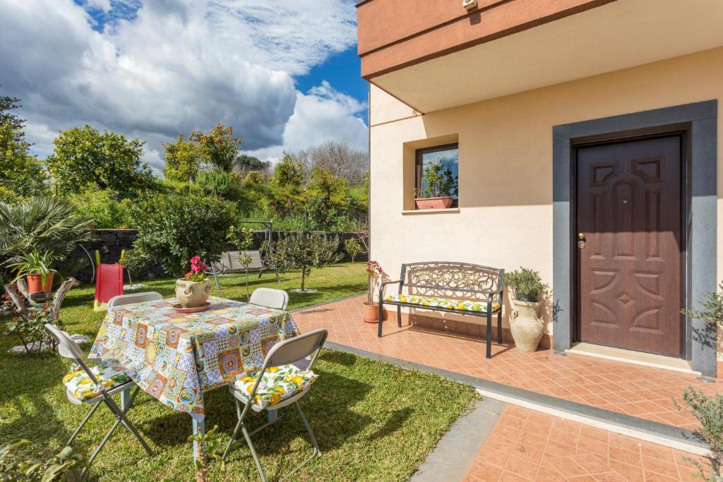 a patio with a table and chairs in a yard at Villa Veronica in Mascali
