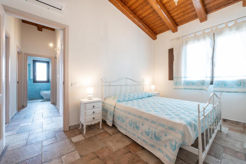 a bedroom with a bed and a bathroom at Villa Tramonto in Villasimius