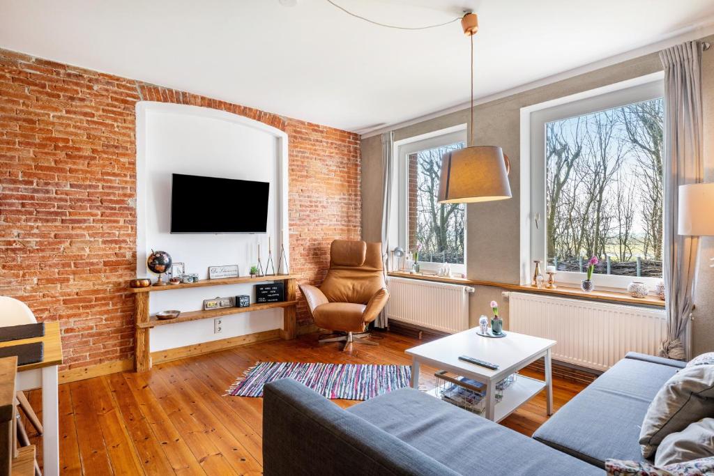 a living room with a couch and a brick wall at Koogbutze in Wesselburenerkoog