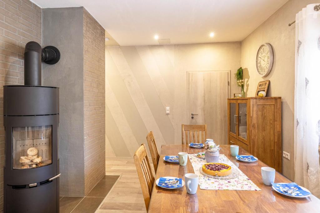 a dining room with a table and a fireplace at Für Traufgängerle in Albstadt