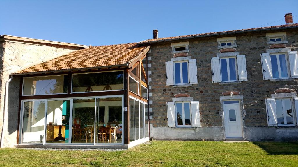 a large brick building with glass doors and windows at La Halte du Pèlerin Chambres d'hôtes in Chérier