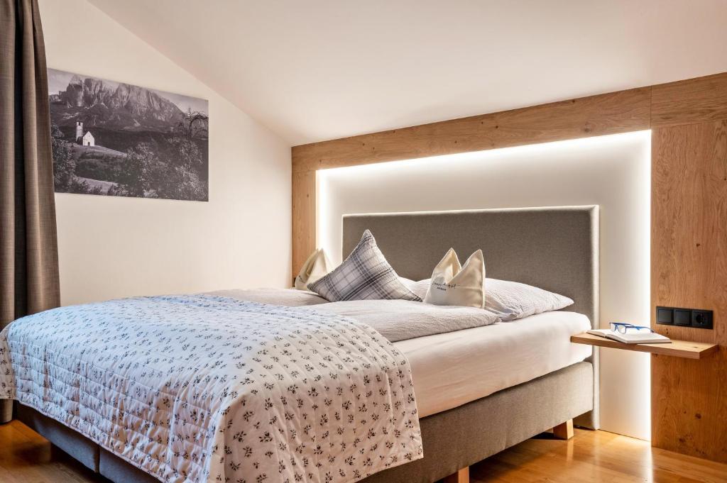 a bedroom with a large bed with a large headboard at Zunerhof Studio Fenn in Longostagno