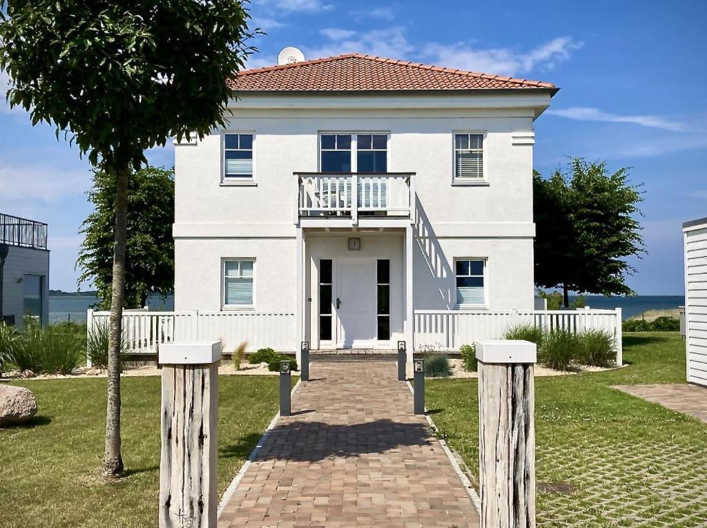 a white house with a walkway in front of it at Sliminde by Seeblick Ferien Oro in Kappeln