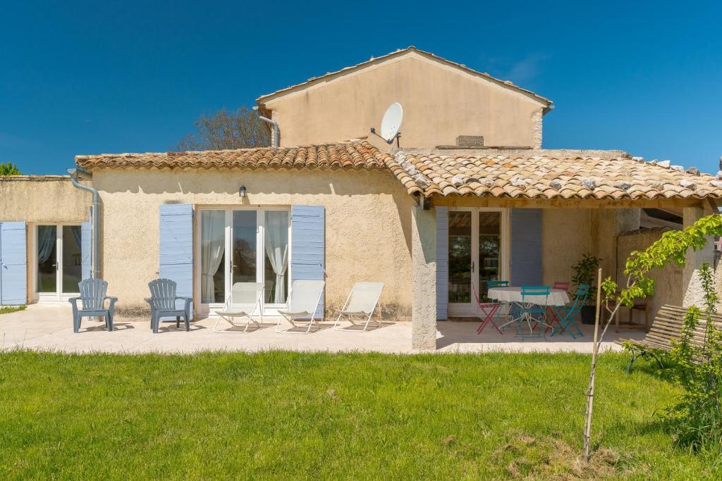 a house with chairs and a table on a patio at La Bellimure in Saint-Christol