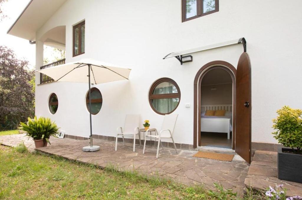 a white house with a table and chairs and an umbrella at La Ginestra Appartamenti e Camere in Mossa