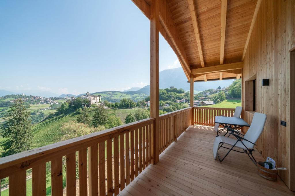a wooden balcony with a desk and chair on it at Hoamat Schlosshof in Völs am Schlern