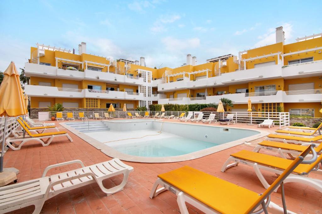 a swimming pool with chairs and a hotel at Royal Cabanas Golf 81 in Conceição