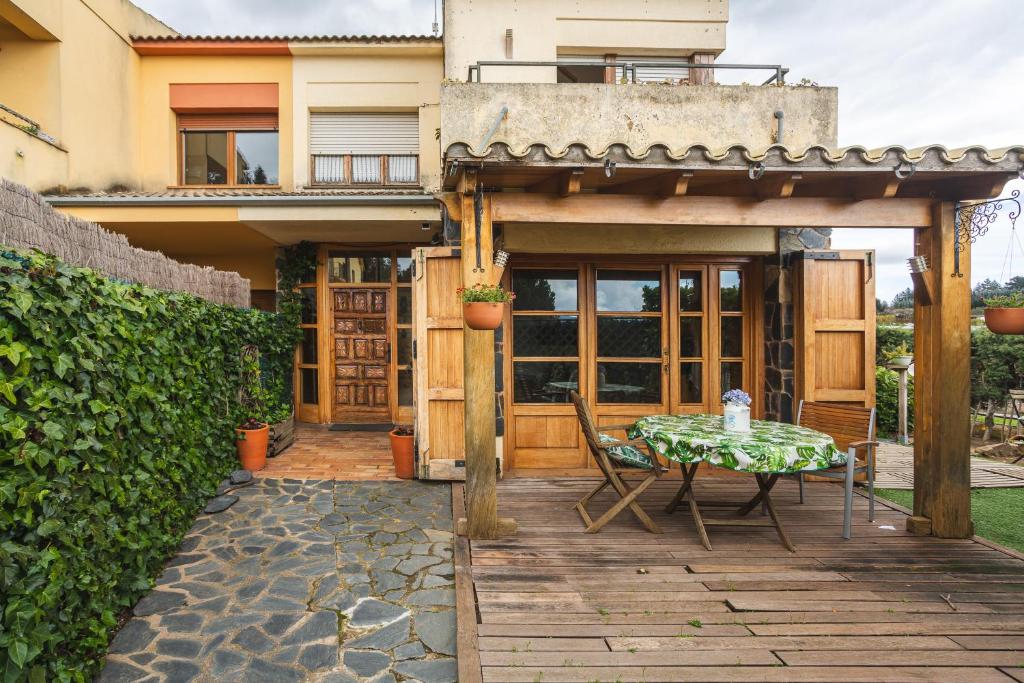 a patio with a table and chairs in front of a house at Can Mussol in Sant Hilari Sacalm