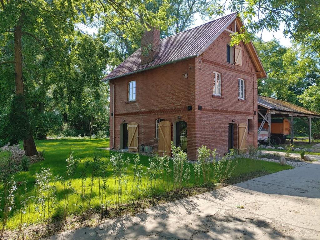 an old red brick house in a field of grass at Ferienhaus Melkerhaus in Neetzendorf