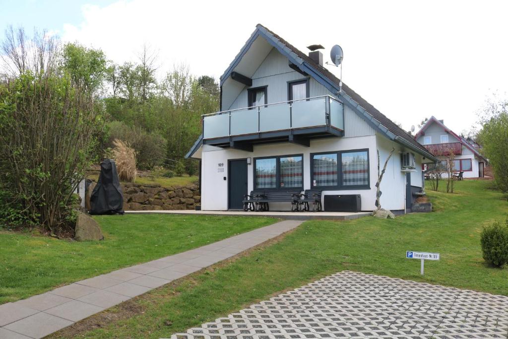 a white house with a balcony on top of it at Ferienhaus 109 - Seepark Kirchheim in Kirchheim