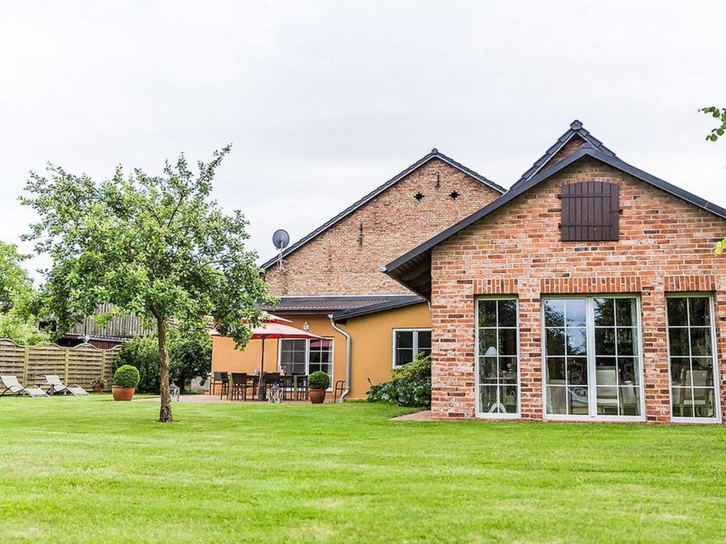 a brick house with a green lawn in front of it at Ferienhaus Sükow in Perleberg