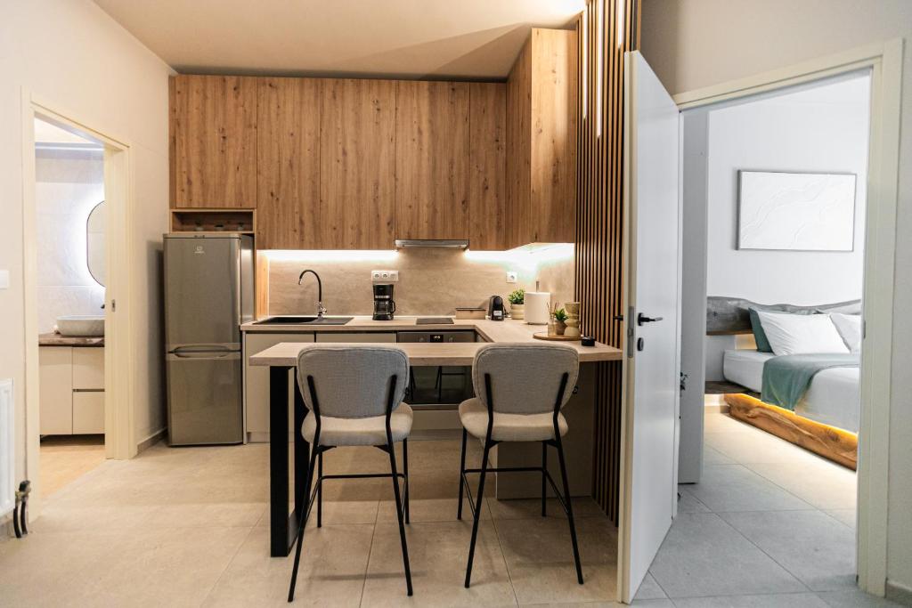 a kitchen with a sink and two bar stools at Sofia's central suite in Alexandroupoli