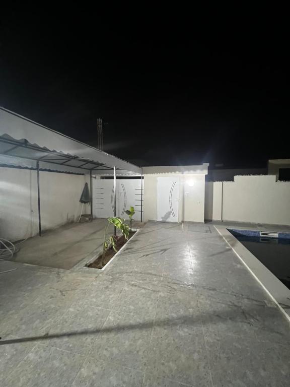 a parking lot with two plants in it at night at Villa charme in Awlād ‘Umar