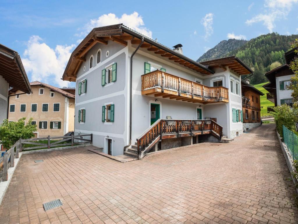 a large white house with a balcony and a patio at Ciasa Lino Sas da le Doudesc in Pozza di Fassa