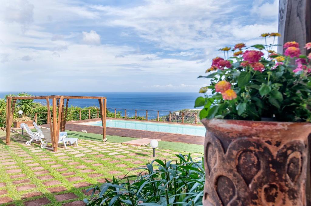 a vase filled with flowers next to a pool at Villa Patrizia in Castelsardo