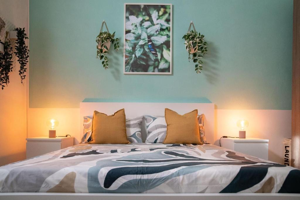 a bedroom with a bed with three plants on the wall at Piave House - Pisa in Pisa