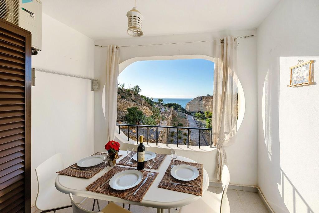a room with a table and a window with a view at Apartamento Mar-colina-sol in Carvoeiro