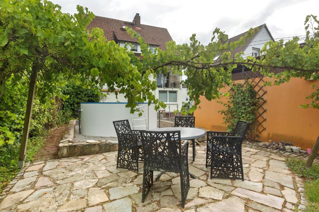 a patio with a table and chairs in a yard at Ferienwohnung Ruhepol, 75qm in Vellmar
