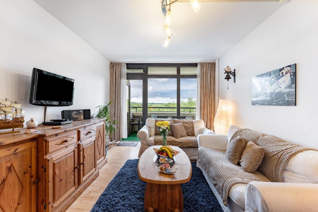 a living room with a couch and a tv at Ferienwohnung 'Segelyachten-Perle' in Schilksee