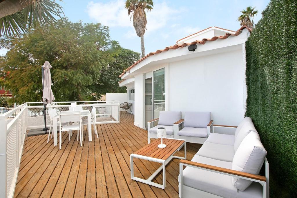 a deck with white furniture and a table at El chiringuito in Candelaria