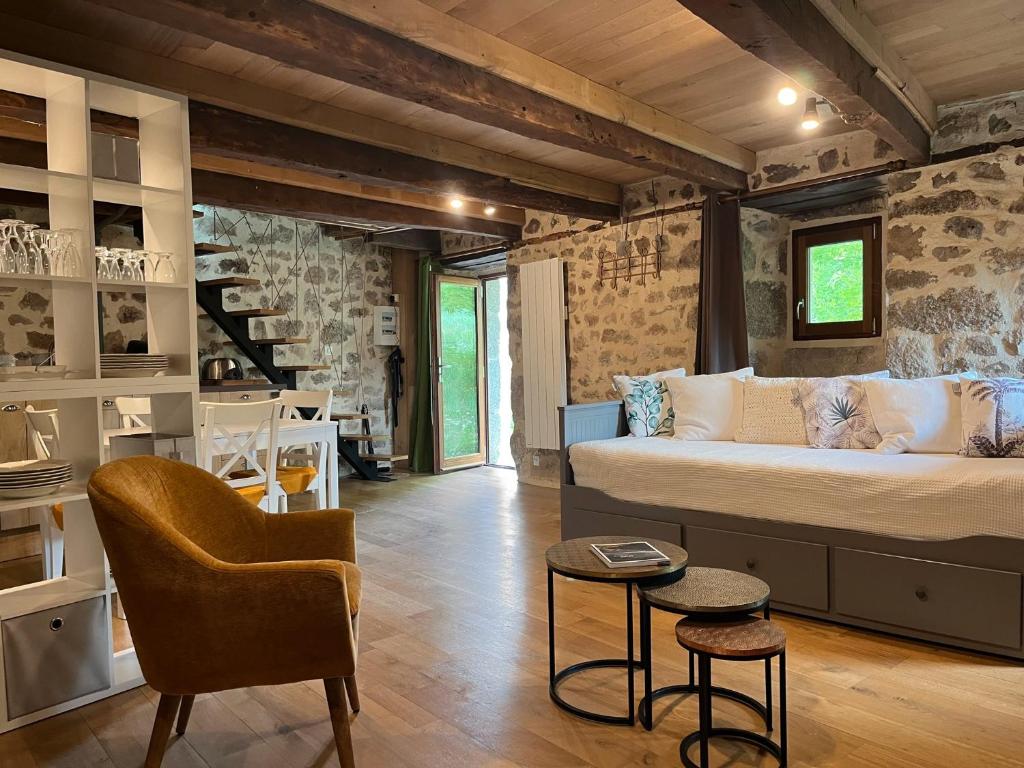 a living room with a bed and a chair at Le Chant du Grillon in Le Nayrac