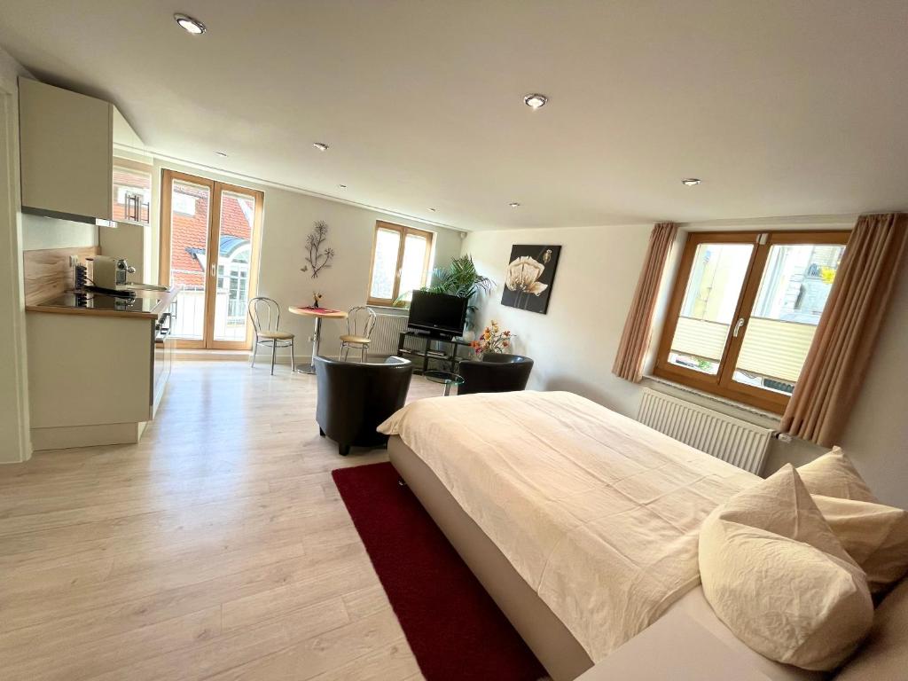 a bedroom with a large bed and a kitchen at Apartment am Schloss in Sigmaringen