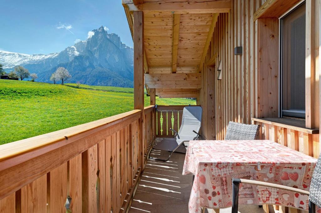 a porch with a table and chairs and a mountain at Schererhof Morgenrot in Castelrotto