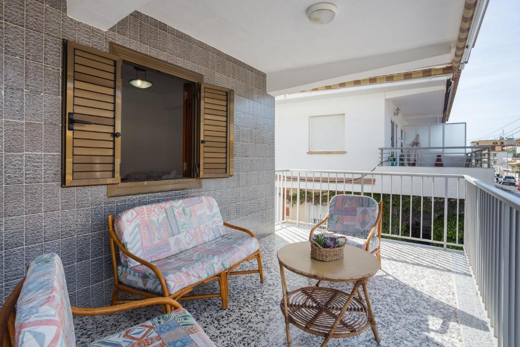 a balcony with two chairs and a table and a tv at Llúria 51 in Oliva