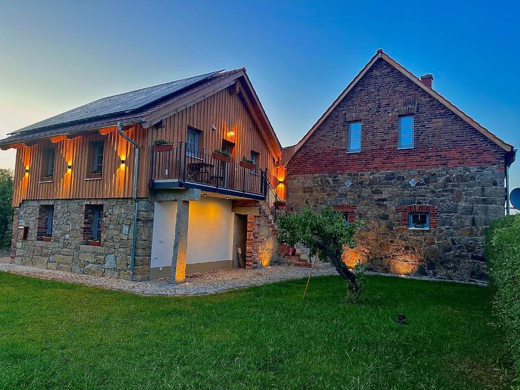 a large brick house with a balcony on it at Aubrac-Biohof Königshainer Berge in Königshain
