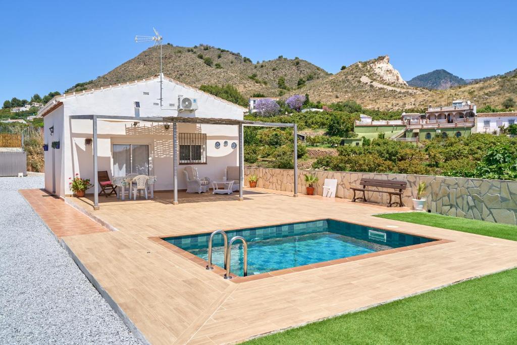 a backyard with a swimming pool and a house at Casa Rural El Granado in Nerja