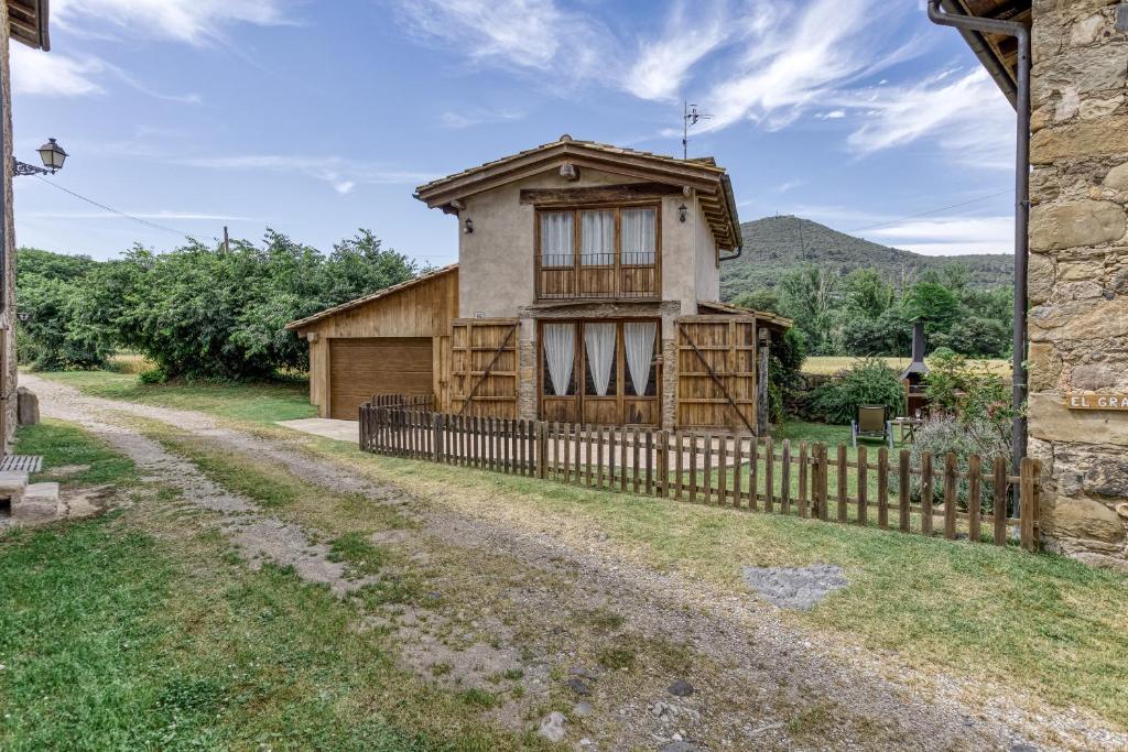 a house with a fence next to a dirt road at El Niu in Montagut