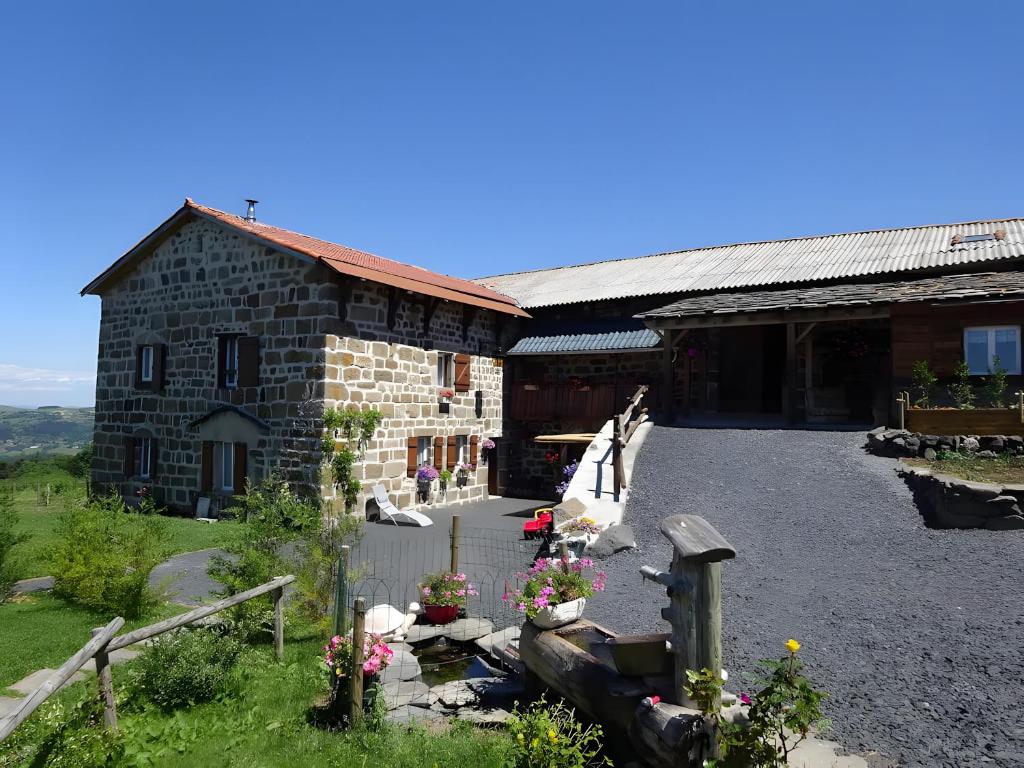 a stone building with flowers in front of it at Le Mont De La Source in Lafarre