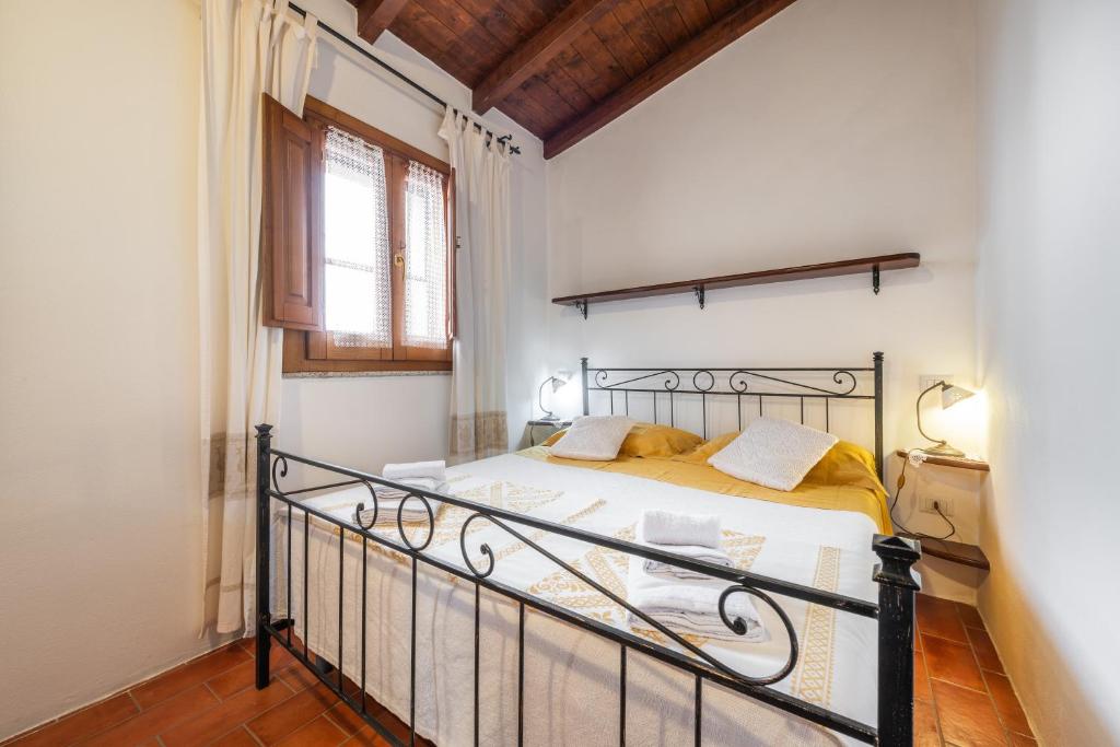 a bedroom with a bed with a wrought iron frame at Agata House in Muravera