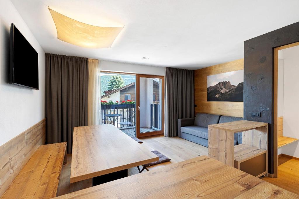 a living room with a table and a couch at Villa Kriendl Nr 4 Dreifinger in Valdaora